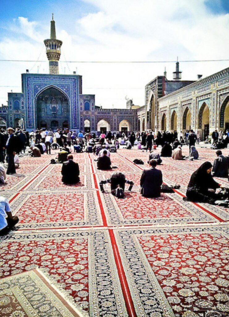 Cour du sanctuaire de l’Imâm Rezâ à Mashhad remplie des tampis avec les pèlerin lors de la prière